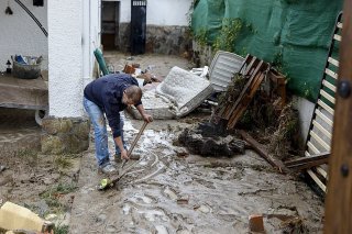 Un homme évacue lundi de la boue de sa maison à Aldea del Fresno.